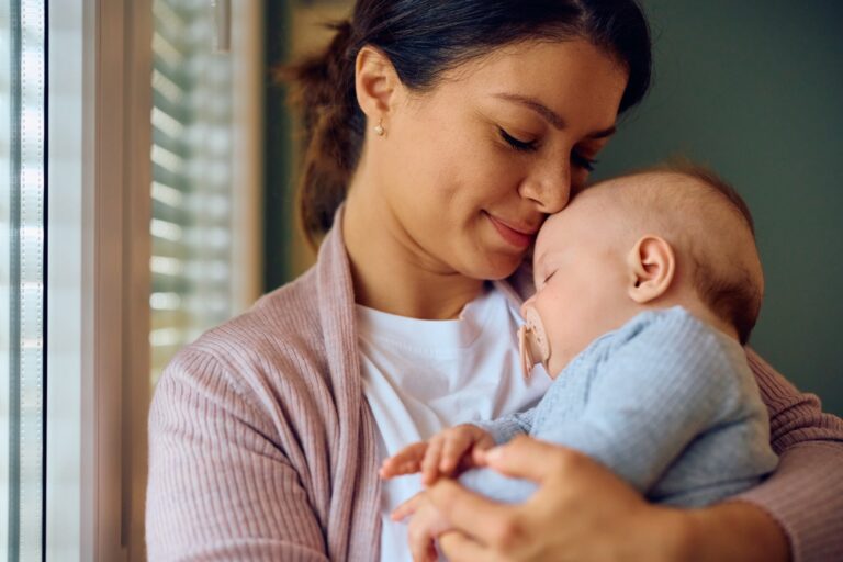 Mother resting at home with her newborn — the best postpartum care package helps mamas heal and thrive